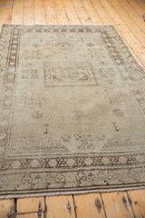 Repeating border pattern and antique ivory fringe on the distressed vintage Khotan rug.