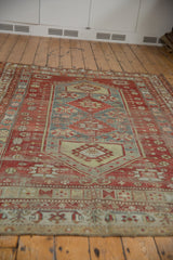 Distressed vintage Caucasian carpet lower border, geometric patterns in red, saffron, and denim blue.