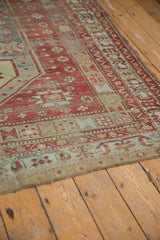 Distressed pile of the vintage Caucasian carpet, showing faded cherry red and denim blue.