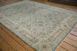 Vintage distressed Sivas carpet with ivory lattice, four seasons motif, dusty teal hues, and even wear.