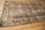 Distressed vintage Malayer rug with faded floral blossoms and muted pale olive, terra cotta tones.