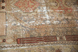 Distressed vintage Malayer rug with prominent wear, exposed foundation, and muted patterns.