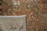 Corner of distressed Malayer rug: worn floral pile, exposed foundation, and light fringe.