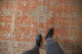 Burnt orange distressed Khotan carpet pile with even wear and geometric silver-ivory patterns.