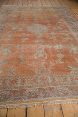 Distressed Khotan carpet's fringe and geometric border, with faded terra cotta and silver.