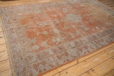 Distressed Khotan carpet showing geometric floral interpretations and a worn texture in terra cotta and silver.
