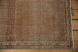 Corner of distressed Serbend rug, showing worn terra cotta field and secure selvage.