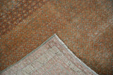 Distressed Mir boteh pattern and woven foundation of a folded Serbend rug corner.