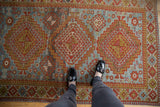 Vintage Distressed Caucasian rug with geometric triple medallions, slate blue, brick red, and gold tones.
