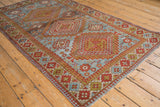 Distressed slate blue and brick red with gold floral guls, geometric motifs on vintage Caucasian rug.