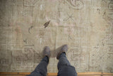 Worn texture of a vintage distressed Khotan rug with faded rose patterns.