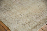 Distressed vintage Khotan rug with visible foundation, delicate plant outlines, and pale blush tones.