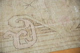 Distressed Vintage Khotan rug, with pale dusty blush and dark outline of germinating plants.