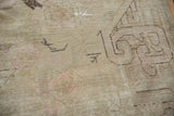 Distressed Khotan rug pile with antique ivory, faint foundation, and charcoal plant outlines.