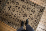 In-room view of a distressed Malayer rug with large-scale geometric patterns in brown and sand.