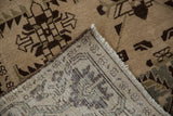 Folded corner of a Persian Malayer rug showing the hand-knotted back and distressed wool pile.
