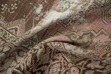 Hand-knotted distressed pile texture with soft mauve, charcoal, and ivory hues.