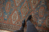 Textured distressed Soumac rug with madder red and sky blue geometric patterns.