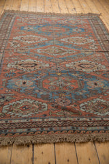 Reciprocating wave and zig-zag borders with distressed tan fringe on an antique Soumac rug.