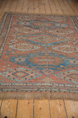 Antique Soumac carpet's geometric motifs, reciprocating wave border, and hand-woven fringe.