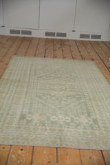 Seafoam green patterned border of a distressed Oushak rug with intact selvage.