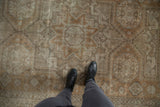 Faded geometric pattern of a distressed Sivas rug underfoot, in coffee brown and beige.