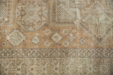 Decorative geometric border with antique ivory and coffee brown tones on a distressed Sivas carpet.