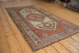 Distressed Caucasian rug corner featuring madder root rust, dusty gold, and pawn border.