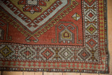 Distressed corner of a vintage Caucasian rug showing pawn motif and madder rust, gold.