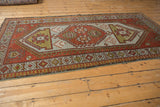 Geometric pawn motif border on distressed vintage Caucasian rug in madder root rust.