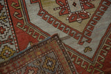 Distressed vintage Caucasian rug corner, showing madder root rust pile and woven side selvage.
