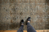 Abrashed field with oversized gul motifs in silver, platinum, and copper tones.