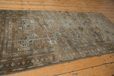 Distressed Belouch runner corner showing faded gul motifs, border, and knot head wear.