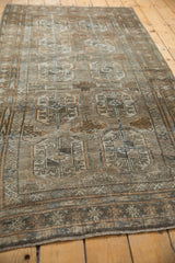 Distressed Belouch rug detail showing worn pile, oxidized silver tones, and subtle geometric pattern.