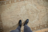 Distressed vintage Oushak rug, with worn hand-knotted pile and faint ivory, beige patterns.