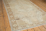 The soft distressed texture of an ivory and beige vintage Oushak rug.