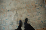 Stylized birds and animals in a geometric field of an ivory and turquoise Afghani rug.