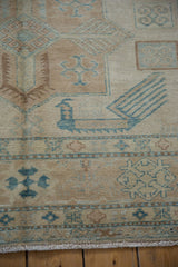 Close-up of hand-knotted Afghani Caucasian carpet: turquoise blue geometric motifs, bird detail, beige field.