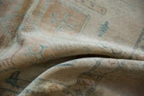Folded short pile of the Afghani rug, revealing geometric patterns in ivory, beige, and turquoise.