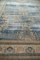 Distressed vintage Oushak rug, faded blue field, beige floral sprays, wear exposing foundation.