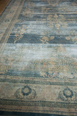 Distressed Oushak rug with mostly even wear, exposed foundation, and stylized blue-beige border.