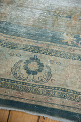 Distressed Oushak carpet displaying worn floral sprays, deep blue border, and mostly even wear across knot heads.