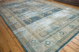 Distressed Oushak rug corner with denim blue floral border and intact side selvage.