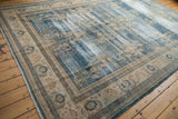 Distressed blue field and beige border with floral motifs on a vintage Oushak rug.