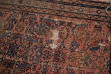 Detail of vintage Hamadan rug, blush and blue Herati pattern, showing scattered holes.