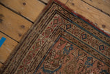 Vintage Hamadan rug corner with dusty rose field, blue Herati motif, and worn geometric borders.