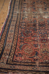 Dusty rose, indigo, and beige geometric border on worn Hamadan rug.