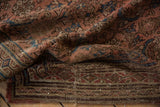 Folded vintage Hamadan runner shows worn border, exposed foundation, and white thread areas.