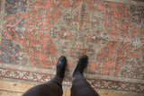 Distressed terra cotta, beige, and dusty blue floral vinery pattern on a vintage Sivas rug, underfoot.