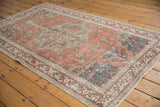 Distressed corner of vintage Turkish Sivas rug with terra cotta, beige, and blue motifs.